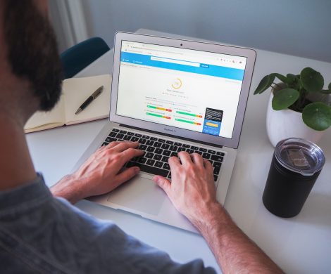 person using macbook pro on white table